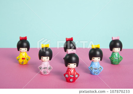 a collection of wooden kokeshi dolls arranged in a triangle like bowling skittles 107870233