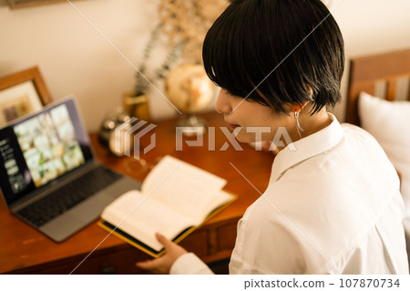 一位短髮女模特兒在家裡房間裡讀書的肖像 107870734