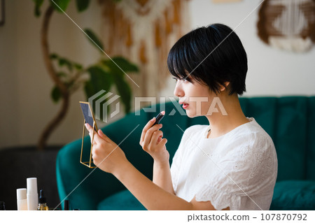 cute woman applying makeup 107870792