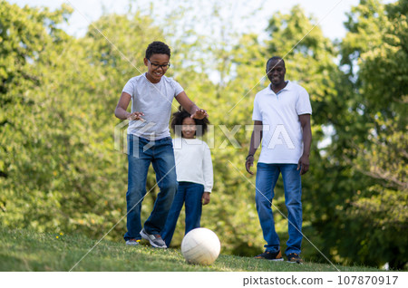 Family playing football in the park Family playing football in the park 107870917