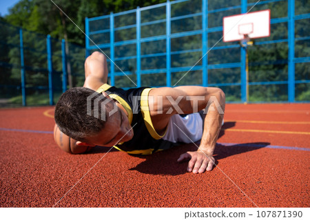 Athletic attractive man training on basketball court. Athletic attractive man training on basketball court. 107871390