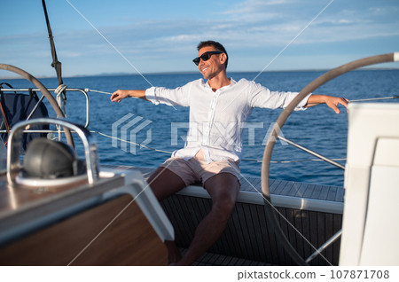 Happy smiling mature man in sunglasses traveling on a yacht Happy smiling mature man in sunglasses traveling on a yacht 107871708