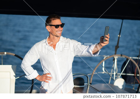 Smiling man traveling on a yacht and looking contented 107871713