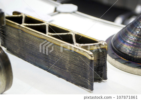 3d printed metal model close-up. Model printed on a 3D printer made of metal. Three-dimensional metal object created by a 3d printer from metal. 3D printing additive modeling manufacturing technology 3d printed metal model close-up. Model printed on a 3D printer made of metal. Three-dimensional metal object created by a 3d printer from metal. 3D printing additive modeling manufacturing technology 107871861