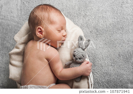 Newborn 3 weeks sleeping with rabbit toy close up. Baby care, colic, teething, healthy sleep.. Newborn 3 weeks sleeping with rabbit toy close up. Baby care, colic, teething, healthy sleep.. 107871941