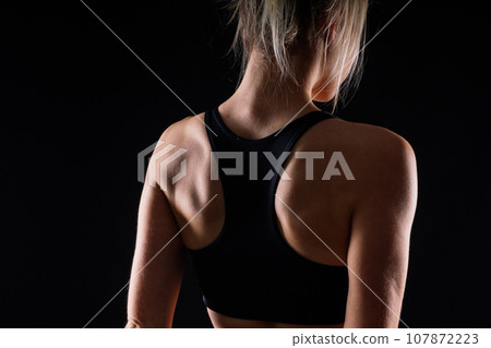 Beautiful young woman dressed in a sports uniform, posing in the studio. Healthy lifestyle, sport Beautiful young woman dressed in a sports uniform, posing in the studio. Healthy lifestyle, sport 107872223