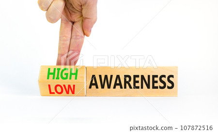 High or low awareness symbol. Concept words High awareness Low awareness on wooden blocks. Beautiful white background. Businessman hand. Business High or low awareness concept. Copy space. 107872516