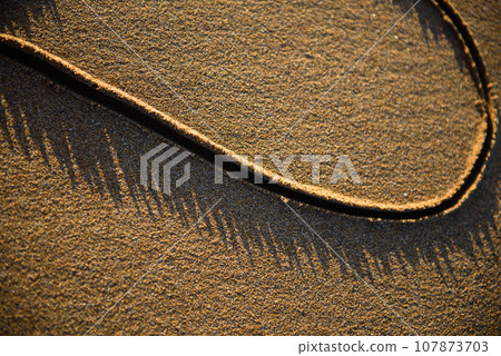 Heart shape drawn in the sand on a beach Heart shape drawn in the sand on a beach 107873703