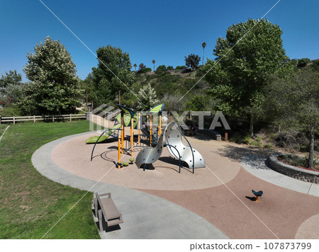 Colorful children playground activities in public park surrounded by green trees Colorful children playground activities in public park surrounded by green trees 107873799
