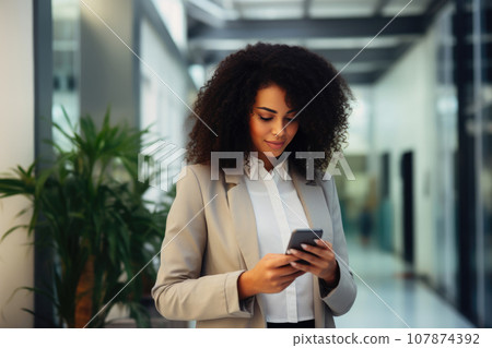 Chic Black Businesswoman Scrolling on Her Phone Chic Black Businesswoman Scrolling on Her Phone 107874392
