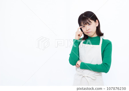 一位三十多歲的家庭主婦在白色背景前憂心忡忡 一位三十多歲的家庭主婦在白色背景前憂心忡忡 107876230