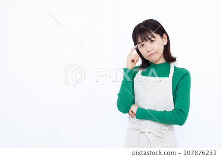 一位三十多歲的家庭主婦在白色背景前憂心忡忡 一位三十多歲的家庭主婦在白色背景前憂心忡忡 107876231