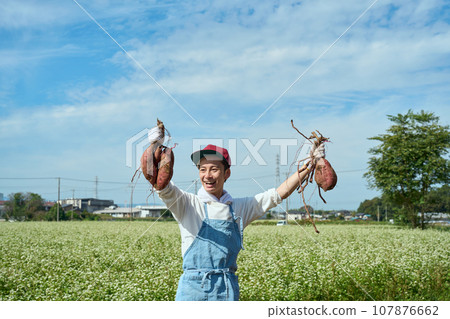 A man holding a sweet potato in his hand 107876662