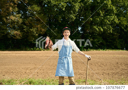 一個男人手裡拿著一個地瓜 107876677