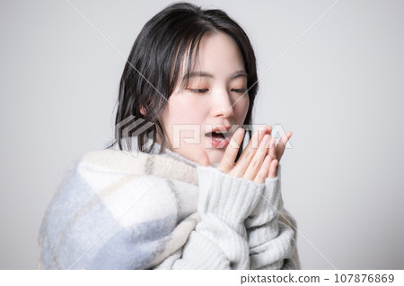 Portrait of a young woman wearing a scarf and knitwear, winter 107876869