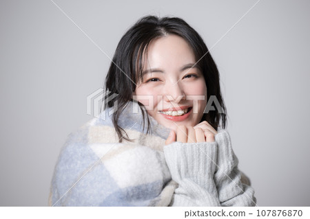 冬天，一位戴著圍巾和針織品的年輕女子的肖像 107876870