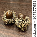 Acorns placed on a brown wooden table 107877651