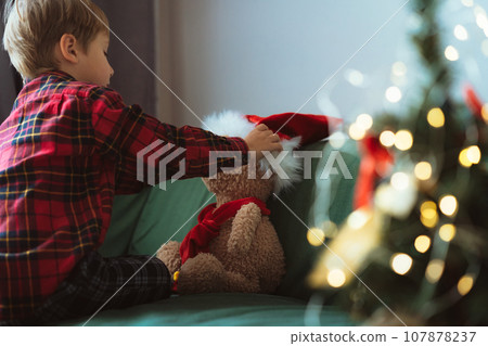 cute little boy dressing up teddy bear cute little boy dressing up teddy bear 107878237