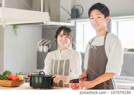 年輕的亞洲夫婦在廚房做飯和做家事(自己做飯,工作,早餐,午餐) 年輕的亞洲夫婦在廚房做飯和做家事(自己做飯,工作,早餐,午餐) 107879186