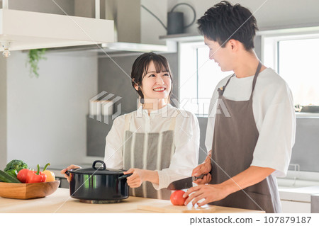年輕的亞洲夫婦在廚房做飯和做家事(自己做飯,工作,早餐,午餐) 年輕的亞洲夫婦在廚房做飯和做家事(自己做飯,工作,早餐,午餐) 107879187