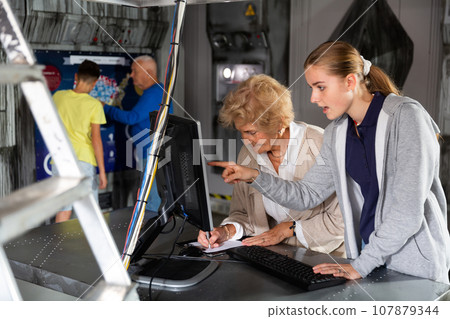 Grandchildren and grandparents solving conundrum in escape room Grandchildren and grandparents solving conundrum in escape room 107879344