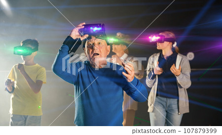 Elderly parents use virtual reality glasses with children 107879399