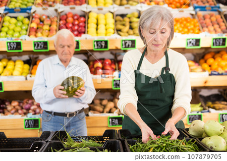Senior female greengrocer worker and client in salesroom Senior female greengrocer worker and client in salesroom 107879705