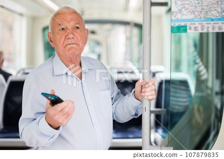 Senior European with smartphone man in tram Senior European with smartphone man in tram 107879835