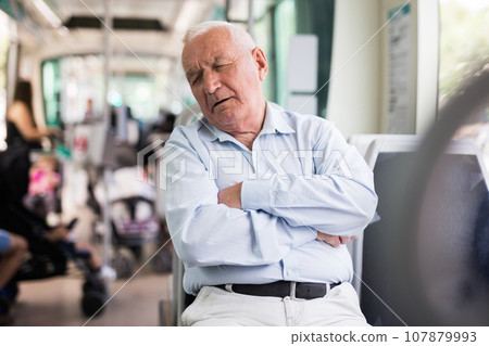 Old man sleeping in streetcar 107879993