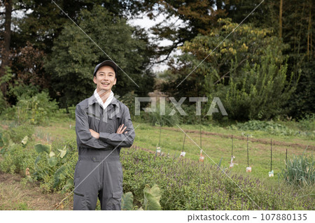 Farmer man smiling and folding his arms in the field Farmer man smiling and folding his arms in the field 107880135