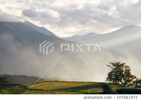 Autumn mountain range covered in clouds 107881972