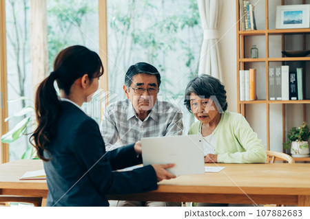 Senior couple discussing their concerns with a consultant 107882683