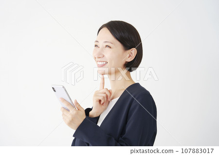 Business woman imagining holding a smartphone, white background Business woman imagining holding a smartphone, white background 107883017