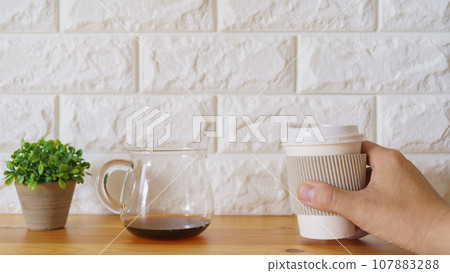 男人的手拿著紙杯裡的咖啡 男人的手拿著紙杯裡的咖啡 107883288
