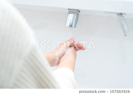 Woman washing hands in the bathroom Woman washing hands in the bathroom 107883926