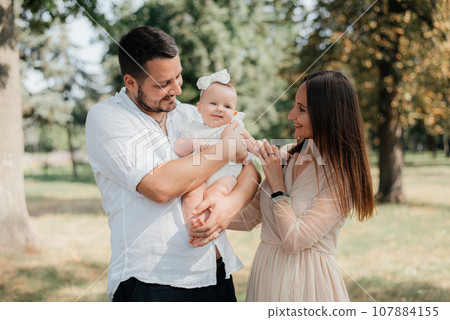 Happy young family with little baby girl outdoors 107884155