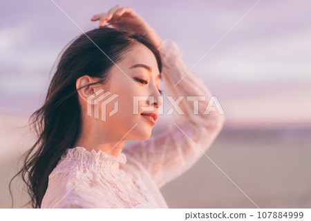Beauty image of a woman bathed in the sunset 107884999