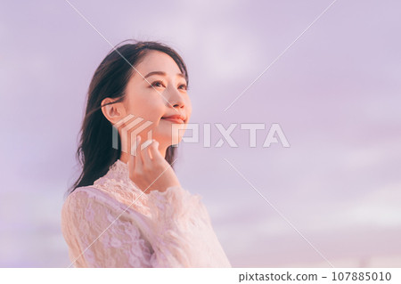 Beauty image of a woman bathed in the sunset 107885010