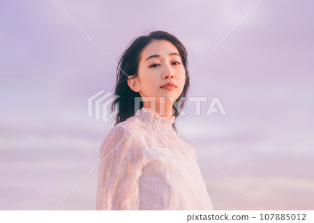 Beauty image of a woman bathed in the sunset 107885012