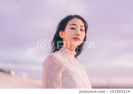 Beauty image of a woman bathed in the sunset 107885014