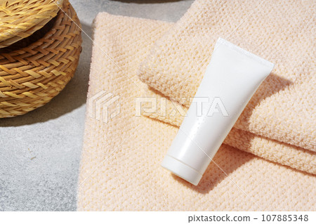 lank cosmetic bottles and towels on gray background lank cosmetic bottles and towels on gray background 107885348