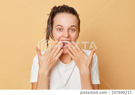 Shocked surprised woman washes hair applies shampoo taking shower isolated over beige background having positive emotions rejoicing something being amazed of result of beauty treatment. Shocked surprised woman washes hair applies shampoo taking shower isolated over beige background having positive emotions rejoicing something being amazed of result of beauty treatment. 107890215