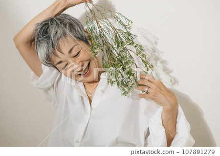 Elegant Japanese woman with gray hair holding flowers Elegant Japanese woman with gray hair holding flowers 107891279