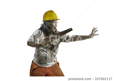 A scary construction worker zombie with blood and wounds on his body walking while carrying a saw 107892117