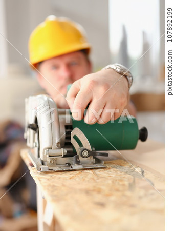 Worker using electric saw portrait 107892199