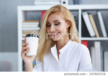 Smiling business woman drinking coffee from Smiling business woman drinking coffee from 107892538