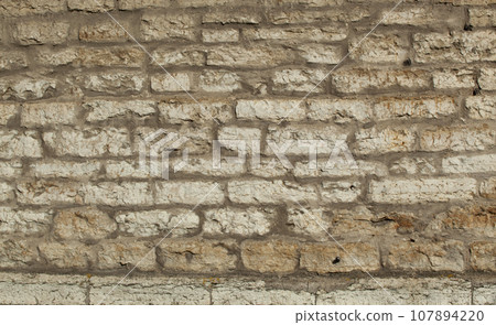 An ancient wall made of gray old bricks in Tallinn. Texture 107894220