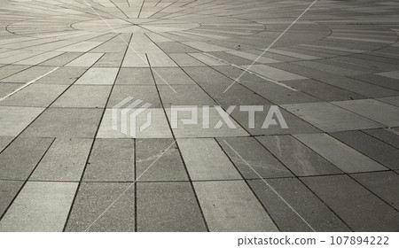 The gray texture of the street sidewalk in the sunlight in Tallinn. 107894222