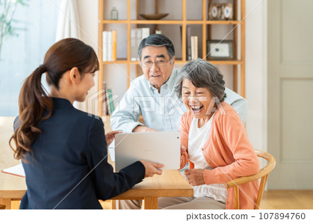 女商人在平板電腦上向年長夫婦解釋 女商人在平板電腦上向年長夫婦解釋 107894760