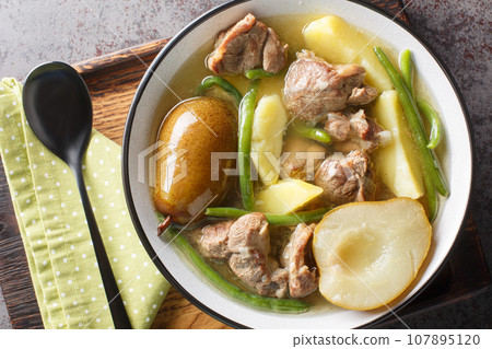 Lamb stew with pears, potatoes, green beans in a spicy sauce close-up in a bowl. horizontal top view Lamb stew with pears, potatoes, green beans in a spicy sauce close-up in a bowl. horizontal top view 107895120